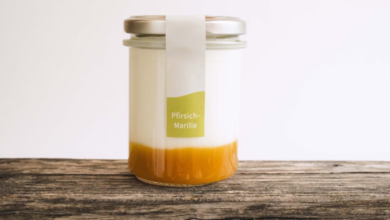 Joghurt Biohof am Stickelberg, © Anni Lechner Fotografie Ein Glas gefüllt mit Naturjoghurt und Fruchtspiegel auf einem Holztisch.