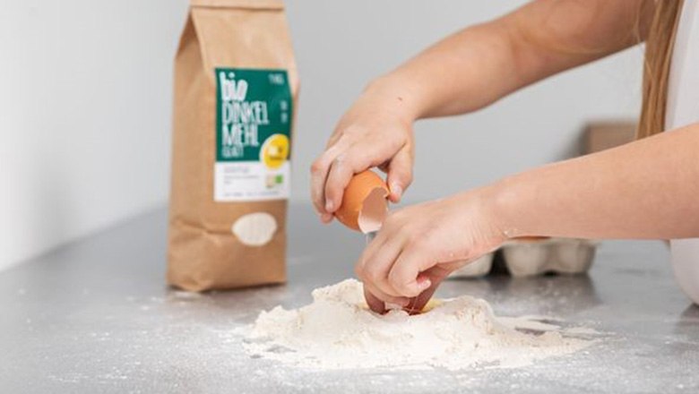 Biohof Trimmel, © Biohof Trimmel Zwei Hände schlagen ein Ei in eine Mulde aus Mehl. Im Hintergrund stehen eine Mehlpackung und ein Eierkarton.