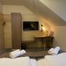 Doppelzimmer, © Hotel Post Hönig Gemütliches Doppelzimmer mit zwei Betten, einem Schreibtisch, einem Fernseher und einem Kleiderschrank.