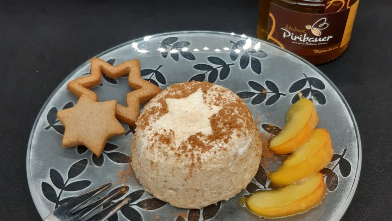 Lebkuchenmousse, © Imkerei Piribauer Teller mit Lebkuchenmousse, Apfelspalten und Lebkuchen, daneben ein Honigglas und eine Gabel.