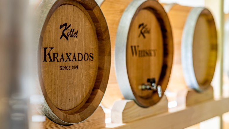 Kraxados im Fass gelagert, © Wiener Alpen, Christian Kremsl Große Holzfässer mit Aufschrift "Kraxados" und "Whiskey" in einem Lagerraum.