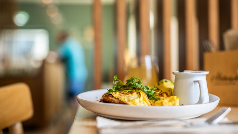Ein Teller mit Omelett und Kr&auml;utern auf einem Tisch in einem Restaurant.