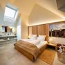 Modernes Hotelzimmer mit Dachfenster, Doppelbett und stilvoller Einrichtung.