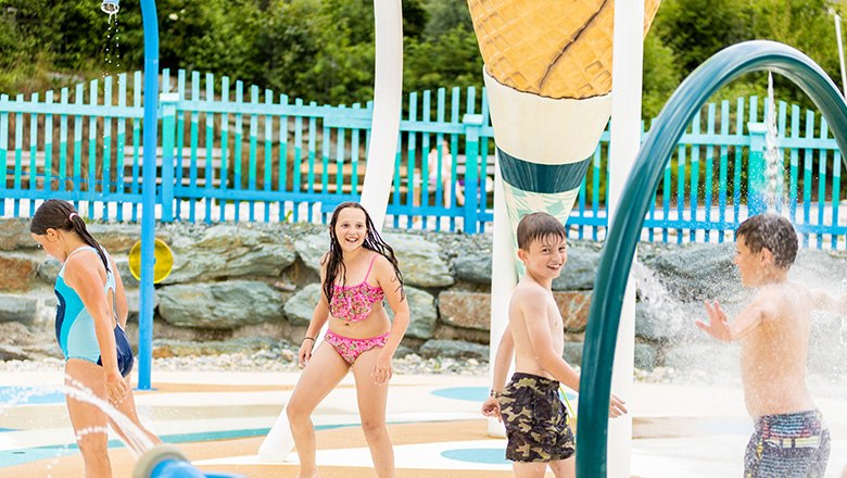 Kinder spielen im Wasserpark im Freien.