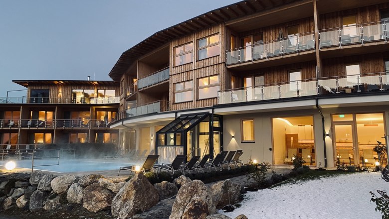 Winterstimmung mit Außenpool, © Peter Pichler Hotelgebäude mit Außenpool und Schnee im Vordergrund.