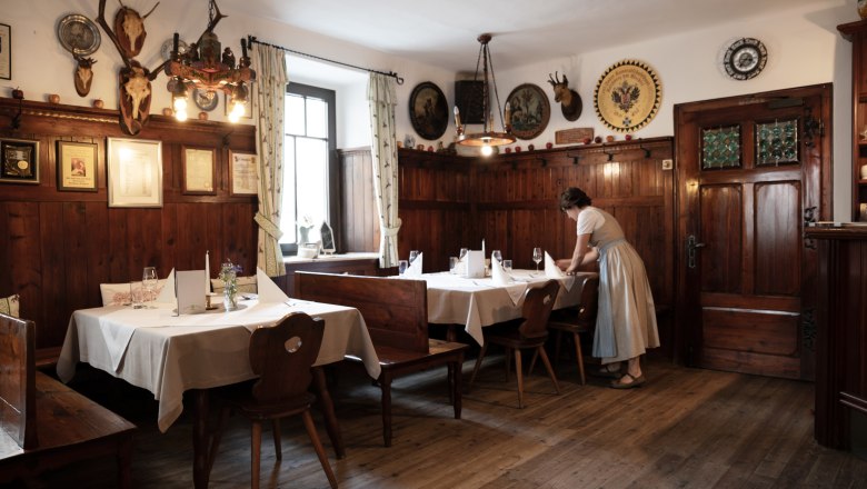 Traditionelles Wirtshaus mit Holzvert&auml;felung und Jagdtroph&auml;en an den W&auml;nden.