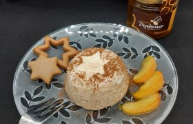 Teller mit Lebkuchenmousse, Apfelspalten und Lebkuchen, daneben ein Honigglas und eine Gabel.